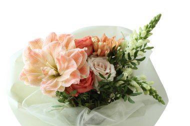 Bir buket şeftali zambağı, portakal ve pembe güller ve bej kasımpatı. Yakın çekim.