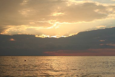 Bir yaz akşamında denizin üzerinde renkli bir gün batımı