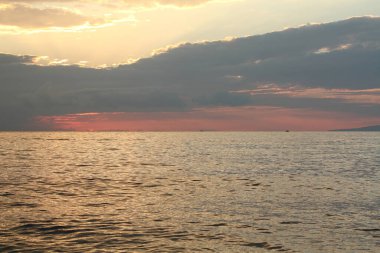 Bir yaz akşamında denizin üzerinde renkli bir gün batımı