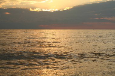 Bir yaz akşamında denizin üzerinde renkli bir gün batımı