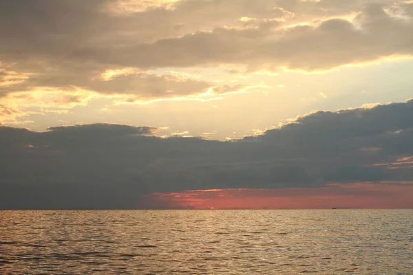 Bir yaz akşamında denizin üzerinde renkli bir gün batımı