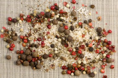 Baharatlar, beyaz, siyah ve kırmızı biberler, gri bir zemine serpiştirilmiş deniz tuzu, yakın çekim üst görüş dar odak çizgisi, sığ alan derinliği