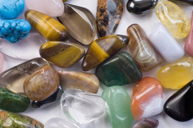 Beyaz desenli arka planda, küçük siyah tabaka üzerinde yarı değerli Gemstone koleksiyonu.