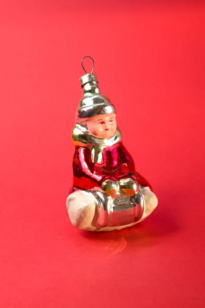Old soviet decoration for the Christmas tree, glass toy little girl close up on red background Stock Photo