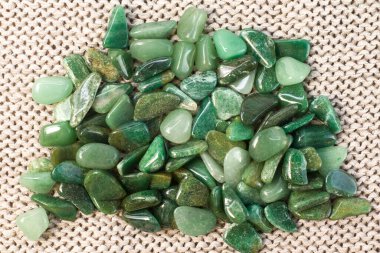 Doğal mineral kaya numunesinin makroskopi - bej arka plan görünümünde yuvarlanan yeşil bulvar taşı