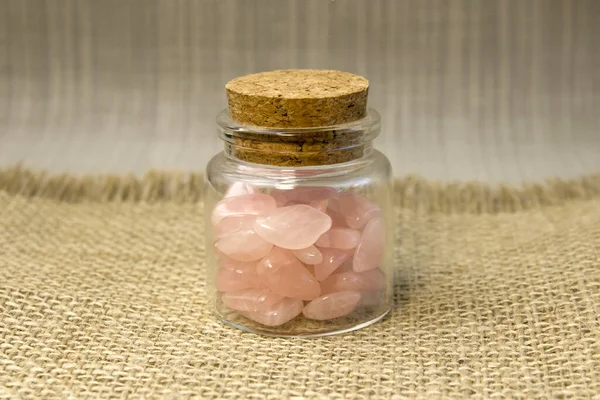 Several pieces of polished pink quartz on glitter pink background. Minimal color still life photography top view