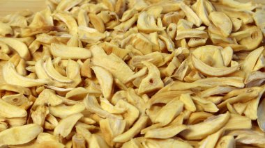 Cam tabakta kurumuş sarımsak taneleri. Gri desenli ahşap arka plan manzarasında düz bir fotoğraf çek.