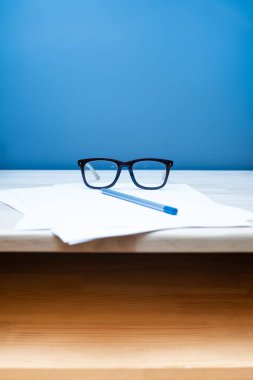 İş yerinde ofis masasında kalem ve gözlüklerle kontrat imzalamak