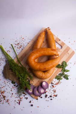 Klasik haşlanmış et domuz sosis biber ve fesleğen ve ahşap arka plan üzerinde kiraz domates ile doğrama tahtası üzerinde. Çocuklar için snack