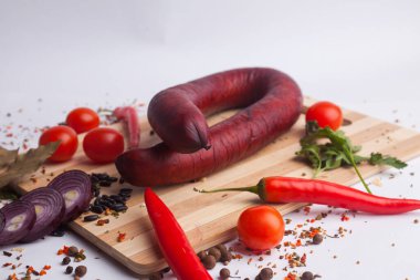 Klasik haşlanmış et domuz sosis biber ve fesleğen ve ahşap arka plan üzerinde kiraz domates ile doğrama tahtası üzerinde. Çocuklar için snack