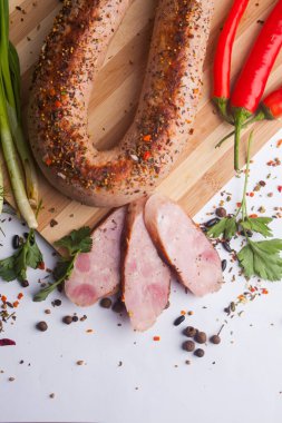 Klasik haşlanmış et domuz sosis biber ve fesleğen ve ahşap arka plan üzerinde kiraz domates ile doğrama tahtası üzerinde. Çocuklar için snack