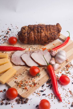 Biberiye ve domatesli ahşap bir tahtada doğranmış domuz eti.