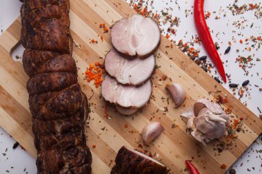 Biberiye ve domatesli ahşap bir tahtada doğranmış domuz eti.