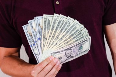 Dolar, bir yelpazenin elinde tuttuğu bir adam tarafından tutulur. Amerikan doları.