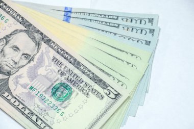 Banknotlar beyaz bir masanın üzerinde duruyor. Bir sürü dolar, bir tomar dolar..