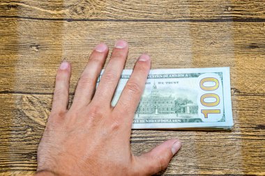 Masadaki adam faturaları tutuyor. Dolarlar hazır..