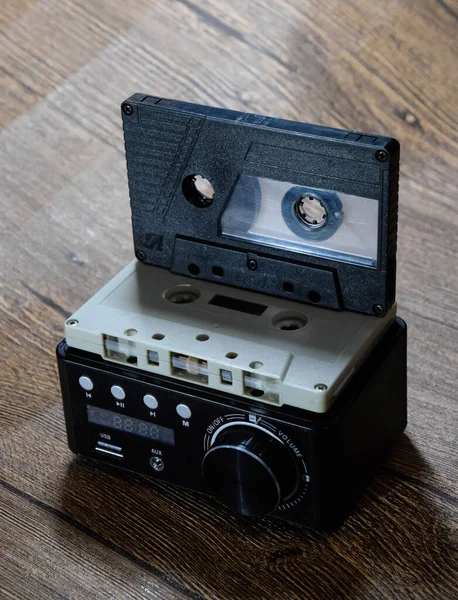 Audio cassette. Retro music medium, compact cassette for tape recorder. Audio cassette next to the amplifier on the table