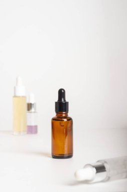Gri arka planda farklı şişelerde kaplıca ürünleri. Uzayı metin için kopyala. Güzellik blogcusu, salon terapisi, markalaşma modeli, minimalizm konsepti. Spa tedavisi için çeşitli yüz masajı yağları