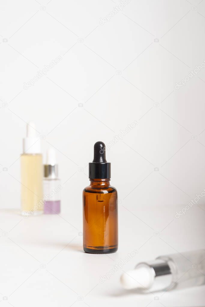 Spa cosmetics in different dropper bottles on grey background. Copy space for text. Beauty blogger, salon therapy, branding mockup, minimalism concept. Various Facial Massage Oils For Spa Treatment