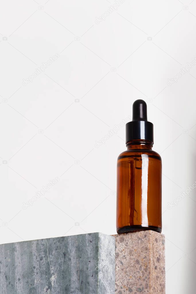 Amber glass dropper bottle with a pipette on a piece of stone. Natural cosmetics concept, natural essential oil