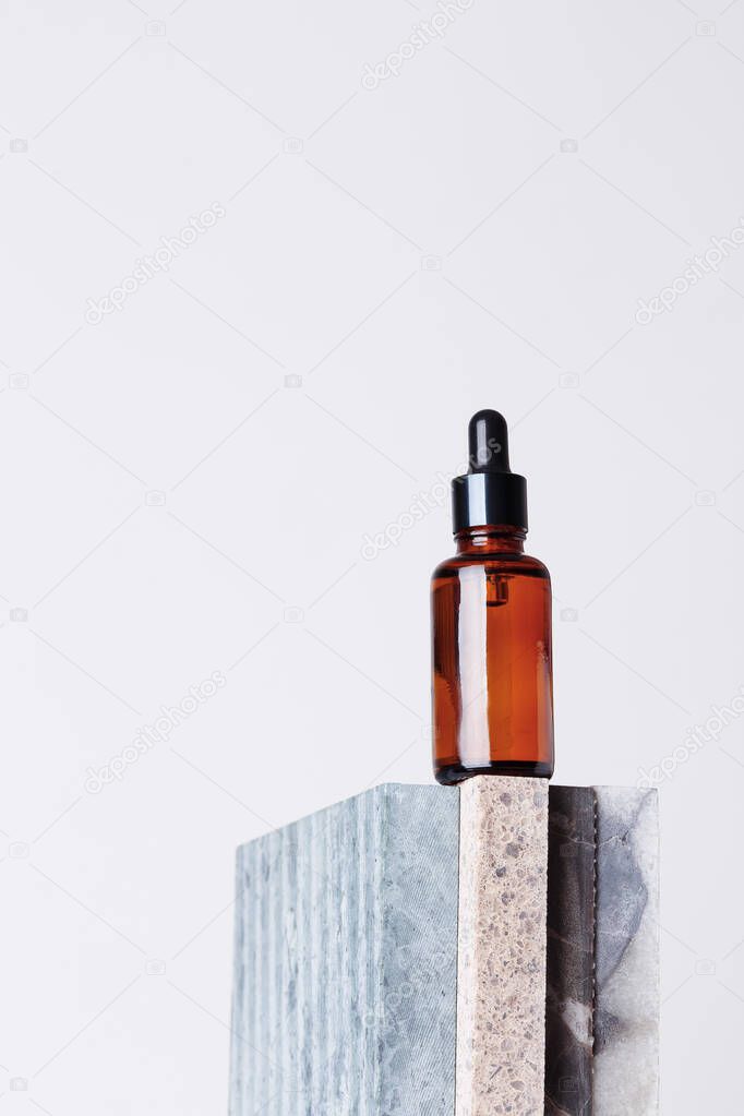 Amber glass dropper bottle with a pipette on a piece of stone. Natural cosmetics concept, natural essential oil