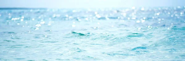 Abstraktes und verschwommenes Ozean- oder Meerwasser mit defokussiertem hellen Sonnenlicht. — Stockfoto