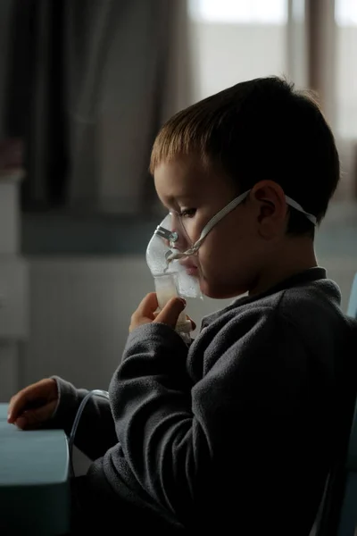 Küçük çocuk evde solunum terapisi sırasında nebulizör kullanıyor. — Stok fotoğraf