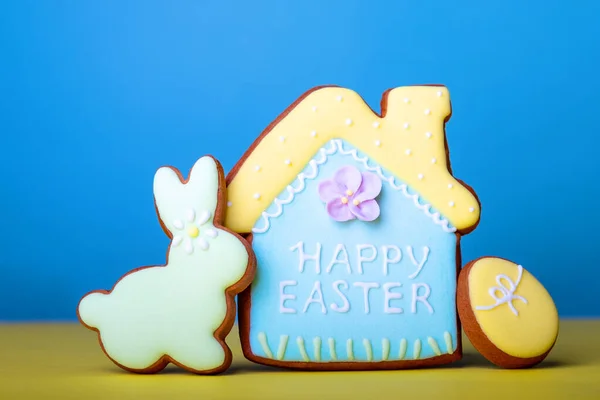Текст счастливой Пасхи и печенье украшены как украшенные пасхальное яйцо на синем фоне — стоковое фото