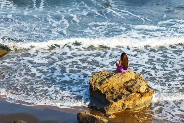 Молодая женщина йоги медитации, памятование на берегу скалы краю. Красивый вид на море. Ветреная погода — стоковое фото
