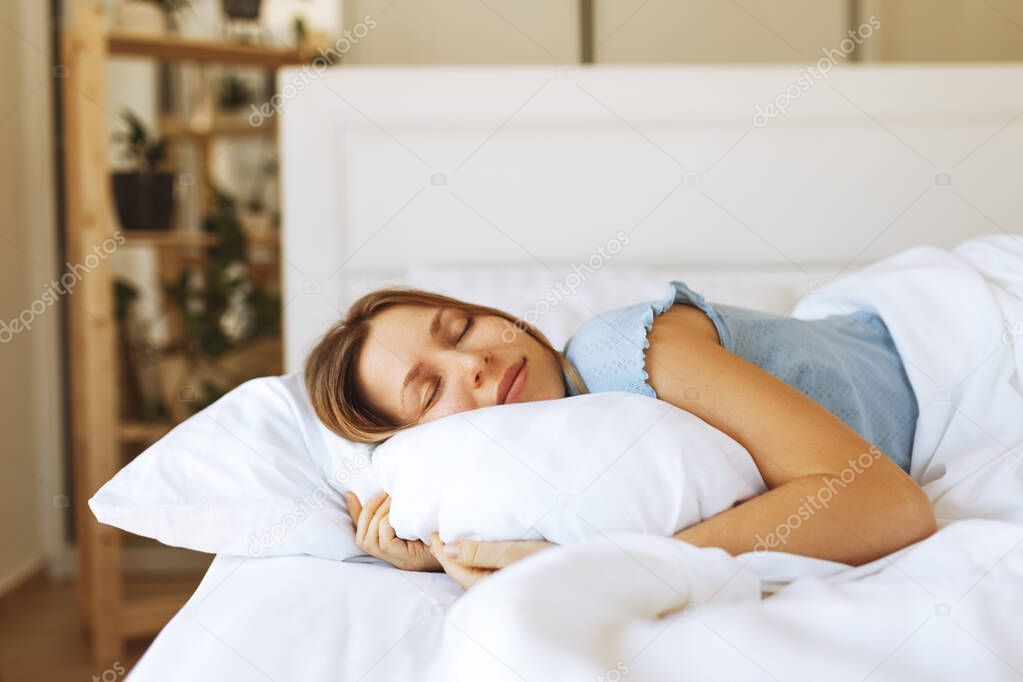 Portrait of young woman enjoying sleeping time in bed , close up ,elevated view, hugging pillow