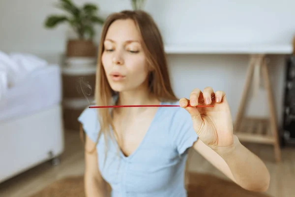 Incense Stick. Caucasian Woman holding, enjoying Aroma Stick