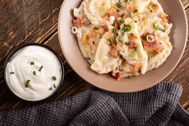 Ahşap masada ekşi kremalı patates köftesi. Geleneksel Ukrayna yemekleri. Varenyky, vareniki, pierogi, pyrohy - dolgulu hamur tatlısı