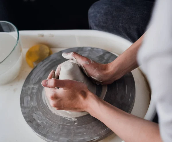 Eller çömlekçilerin çarkının arkasında.