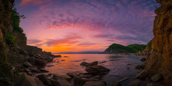 海によって山の上の夕日 ストック写真