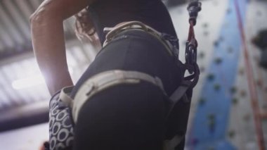 Yakından sporcu atletik kız kaya tırmanışçısı bir bez torbaya magnezyum koyar, elini ve elini pudraya batırır. Spor salonuna tırmanıyorum.
