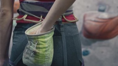 Spor atletik kadın kaya tırmanışı için magnezyum kullanır. Bir solo kapalı spor salonunda eğitilir. Avuç içi için talk pudrası.