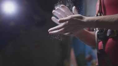 Spor atletik kadın elleri için magnezyum kullanıyor, yakın plan. Talk pudrasından toz uçakları, beyaz tebeşir tozu. Spor salonunda tek başıma tırmanıyorum.