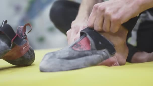 UFA RUSSIA - 09.30.21: Sporty girl rock climber puts on climbing shoes, footwear designed for rock climbing. Climbing clothing. Sports hobby in the city. — Stock Video