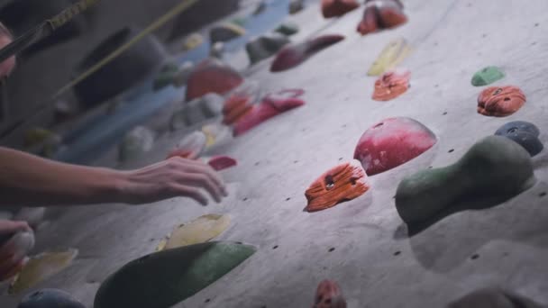 Sportief meisje bergbeklimmer is bezig op een kunstmatige muur in de sportschool. Atletische vrouw Graspende stenen en richels. Rotzooien in de stad. Langzame beweging — Stockvideo