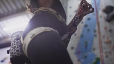 Yakından sporcu atletik kız kaya tırmanışçısı bir bez torbaya magnezyum koyar, elini ve elini pudraya batırır. Spor salonuna tırmanıyorum.