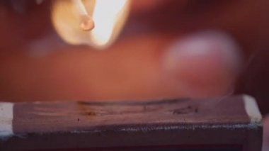 Ucunda ateş olan kibrit çöpü. Kibrit kutusundaki kibrit çöpü ağır çekimde yanar. Kara Arkaplan ile Ateşleme Karşılaşması Macro Shot 'u. Yazdırma kibriti
