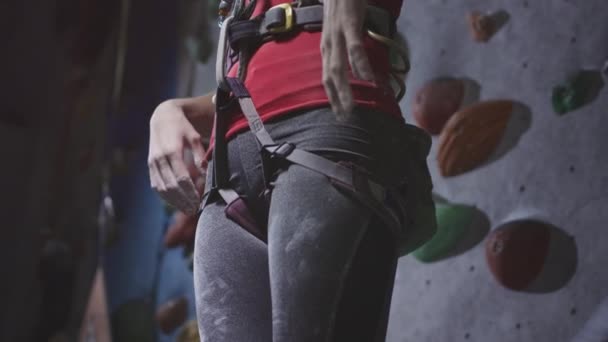 Deportiva atlética mujer utiliza magnesio para las manos, primer plano. El polvo vuela del polvo de talco, polvo de tiza blanca. Escalada en solitario en gimnasio interior — Vídeo de stock