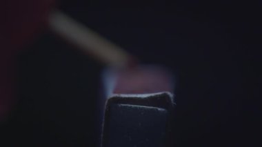 Ucunda ateş olan kibrit çöpü. Kibrit kutusundaki kibrit çöpü ağır çekimde yanar. Kara Arkaplan ile Ateşleme Karşılaşması Macro Shot 'u. Yazdırma kibriti