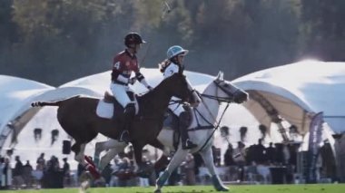UFA RUSSIA - 05.09.2021: Polo oyunu, yavaş çekim. İki oyuncu takımı yeşil çimen stadyumunda ata biniyor. Topa vurdular..