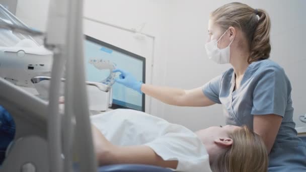 Doctor scans the patients teeth in the clinic. The dentist holds in his hand a manual 3D scanner for the jaw and mouth. Dental health — Stock Video