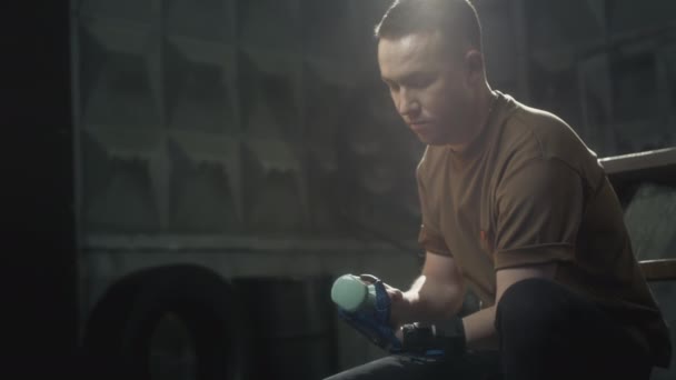 A disabled man with a prosthetic hand raises a dumbbell. Does sports, builds muscle. A fulfilling life with a cybernetic hand prosthesis, inclusiveness — Wideo stockowe