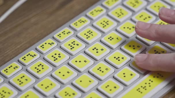 Közelkép egy számítógép billentyűzetről Braille-lel. Egy vak lány szavakat gépel a gombokra a kezével. Látássérült személyek számára készült technológiai eszköz. — Stock videók