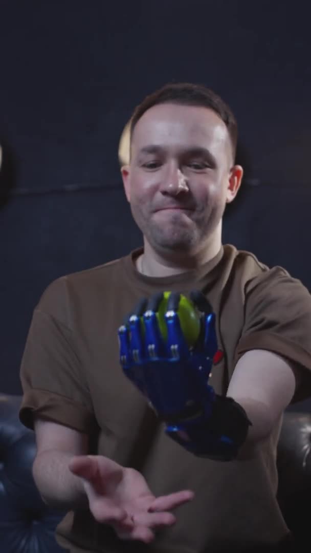 A disabled man with a prosthetic hand juggles a green apple. A fulfilling life with a cybernetic hand prosthesis, inclusiveness. — Stock Video