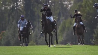 UFA RUSSIA - 05.09.2021: Polo oyunu, yavaş çekim. İki oyuncu takımı yeşil çimen stadyumunda ata biniyor. Topa vurdular..