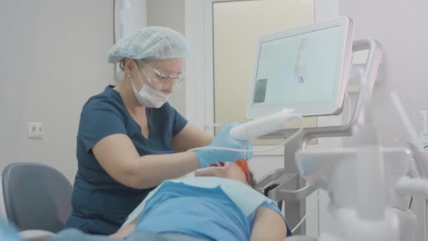 女医生对一名女病人的牙齿进行3D扫描。创建一个3D的下颚模型，治疗口腔。牙科诊所. — 图库视频影像